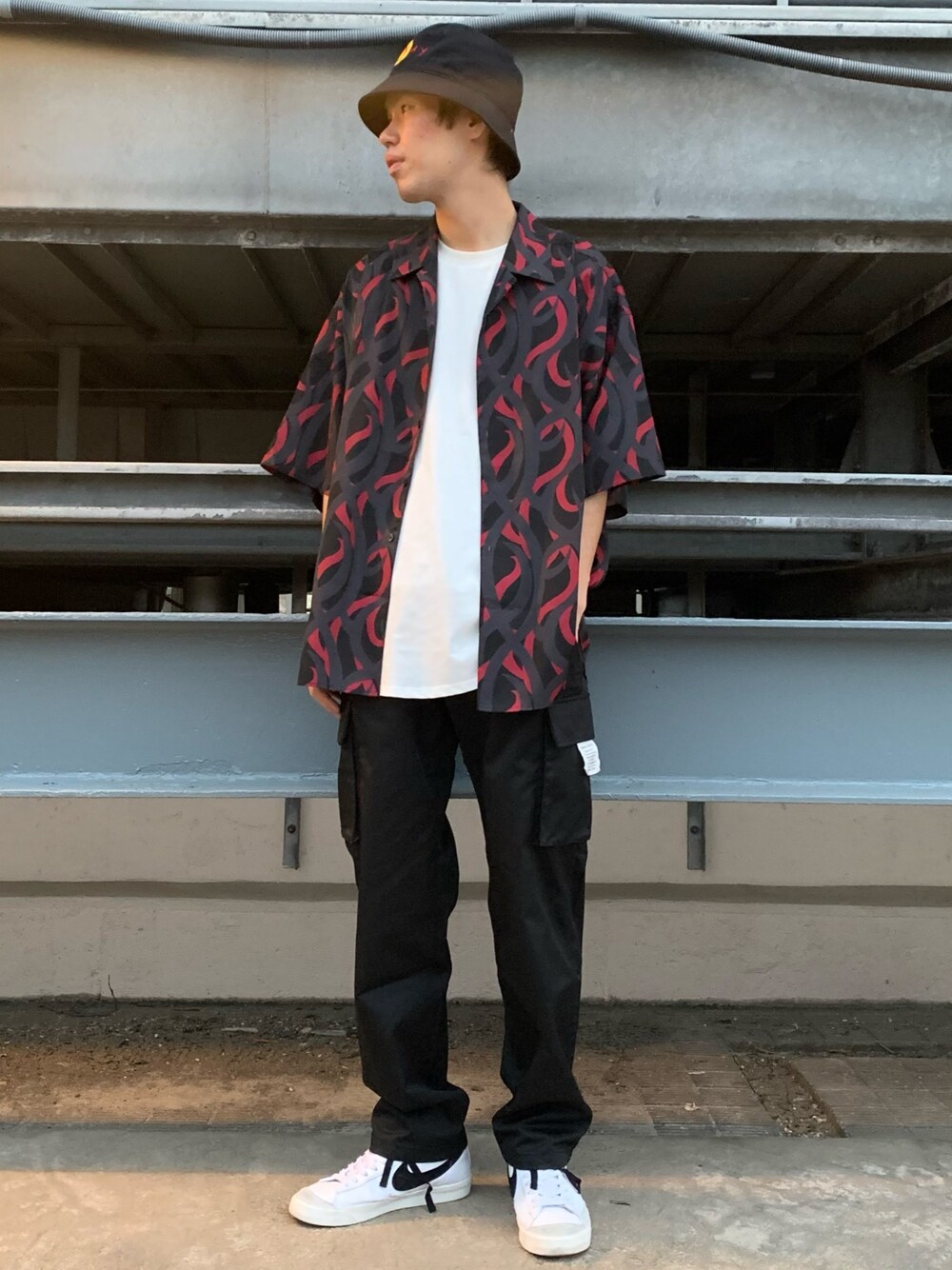 ブラック系のカーゴパンツ、ブラック系のその他パンツ、ホワイト系のTシャツ/カットソーを着用したメンズの春コーディネートの1枚目の写真