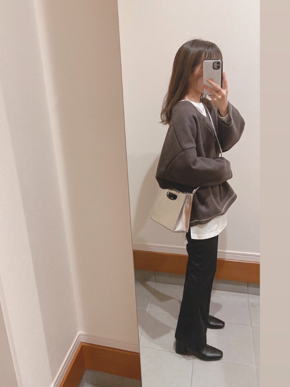 ホワイト系のTシャツ/カットソー、シルバー系のショルダーバッグ、ブラック系のパンツを着用したレディースの冬コーディネートの1枚目の写真