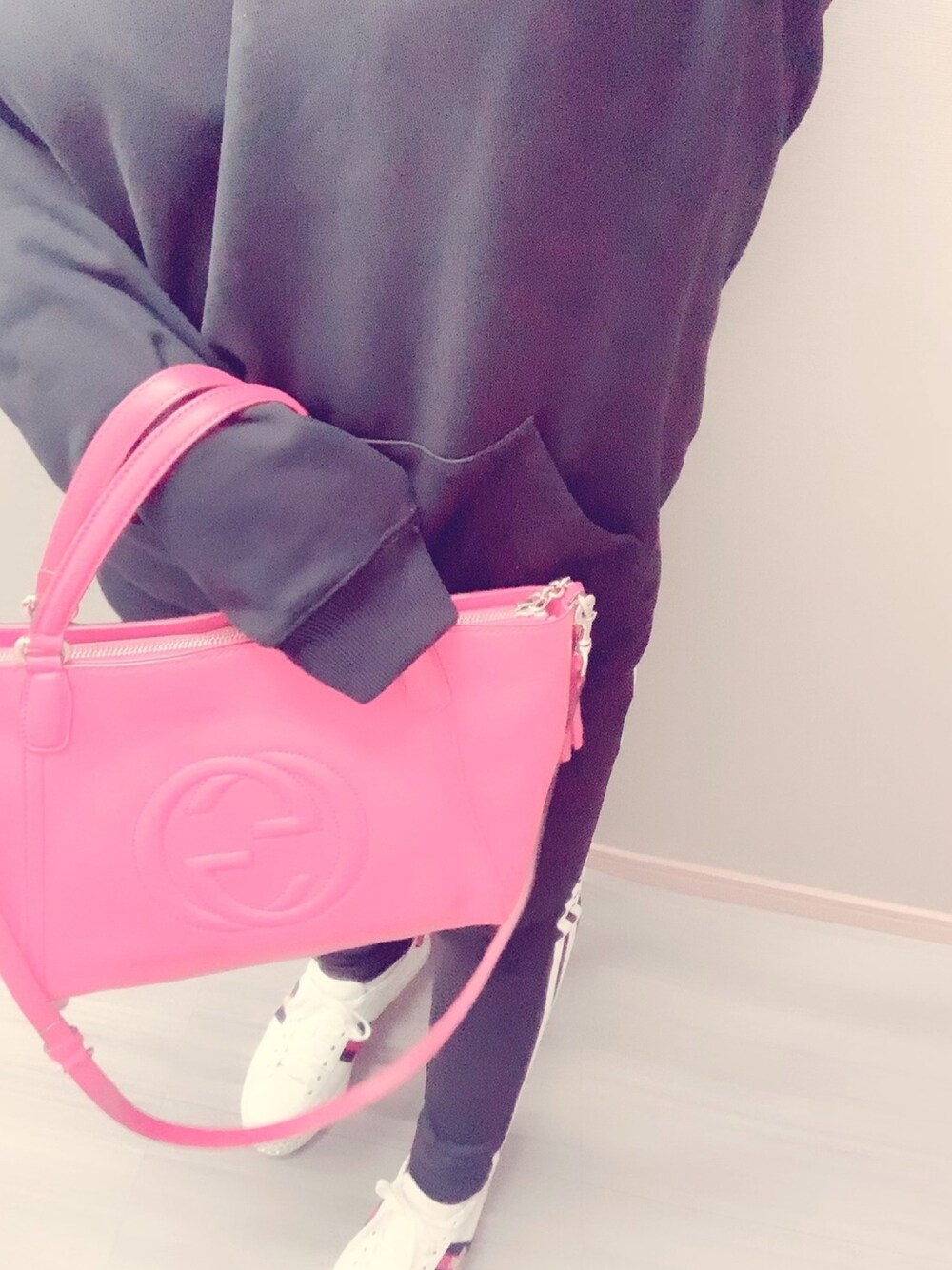 レッド系のショルダーバッグ、ブラック系のパーカー、ブラック系のその他パンツを着用したレディースの冬コーディネートの1枚目の写真