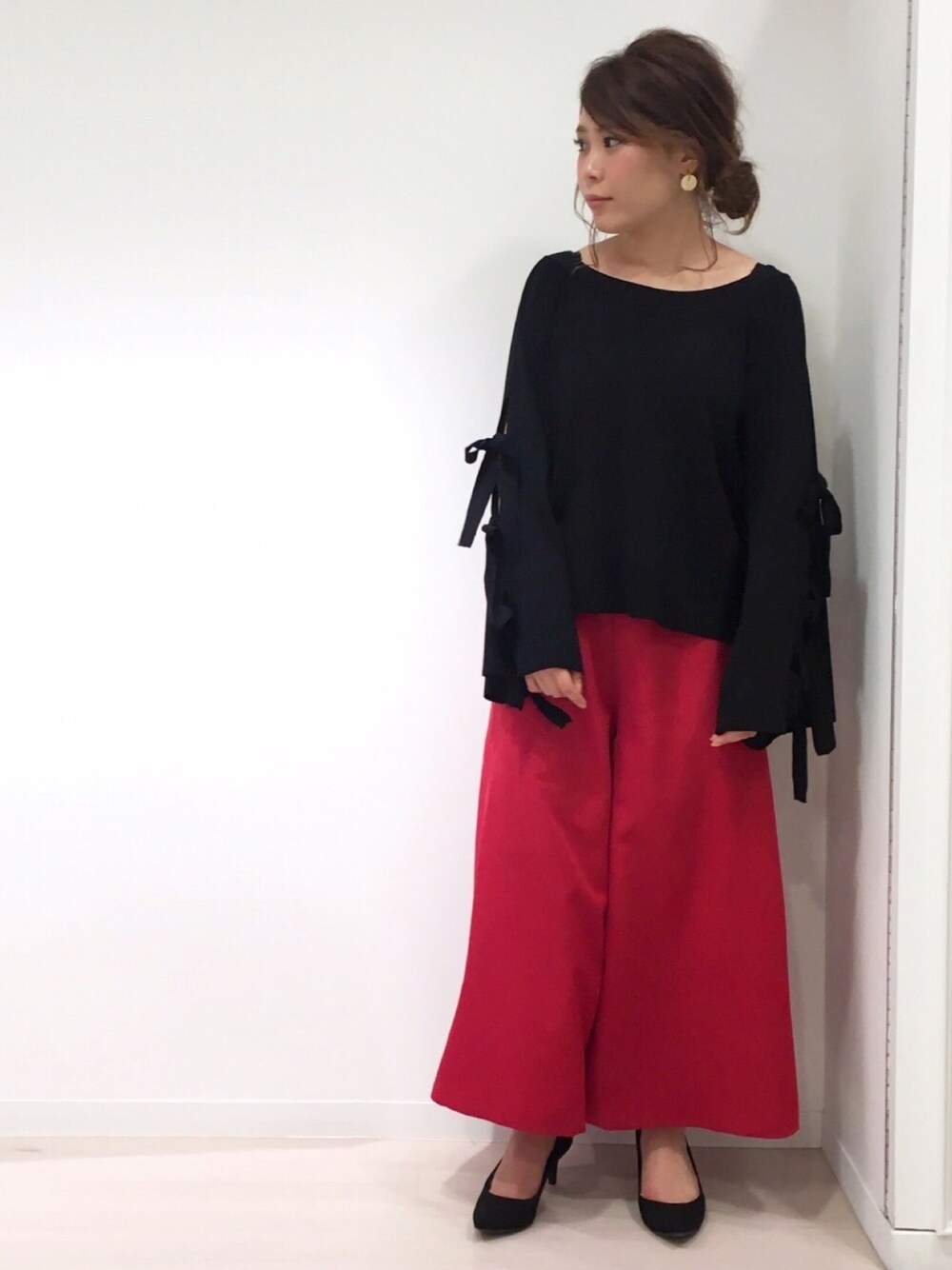 ブラック系のニット/セーター、レッド系のその他パンツ、ブラック系のパンプスを着用したレディースの夏コーディネートの1枚目の写真