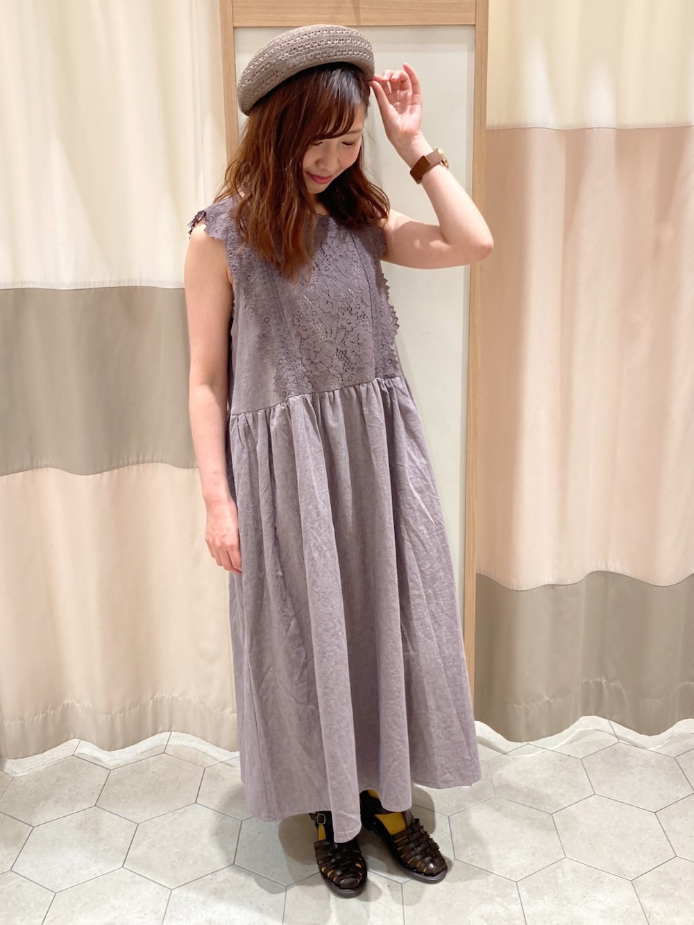 ブラウン系のワンピース、ベージュ系のTシャツ/カットソー、ブラウン系のサンダルを着用したレディースの春コーディネートの1枚目の写真
