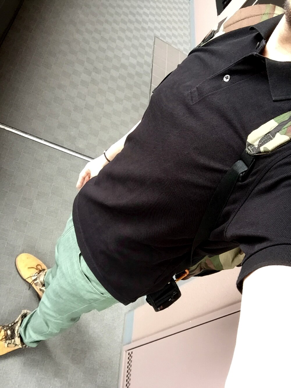 ホワイト系のポロシャツ、グリーン系のチノパンツ、ブラウン系のブーツを着用したメンズの夏コーディネートの1枚目の写真