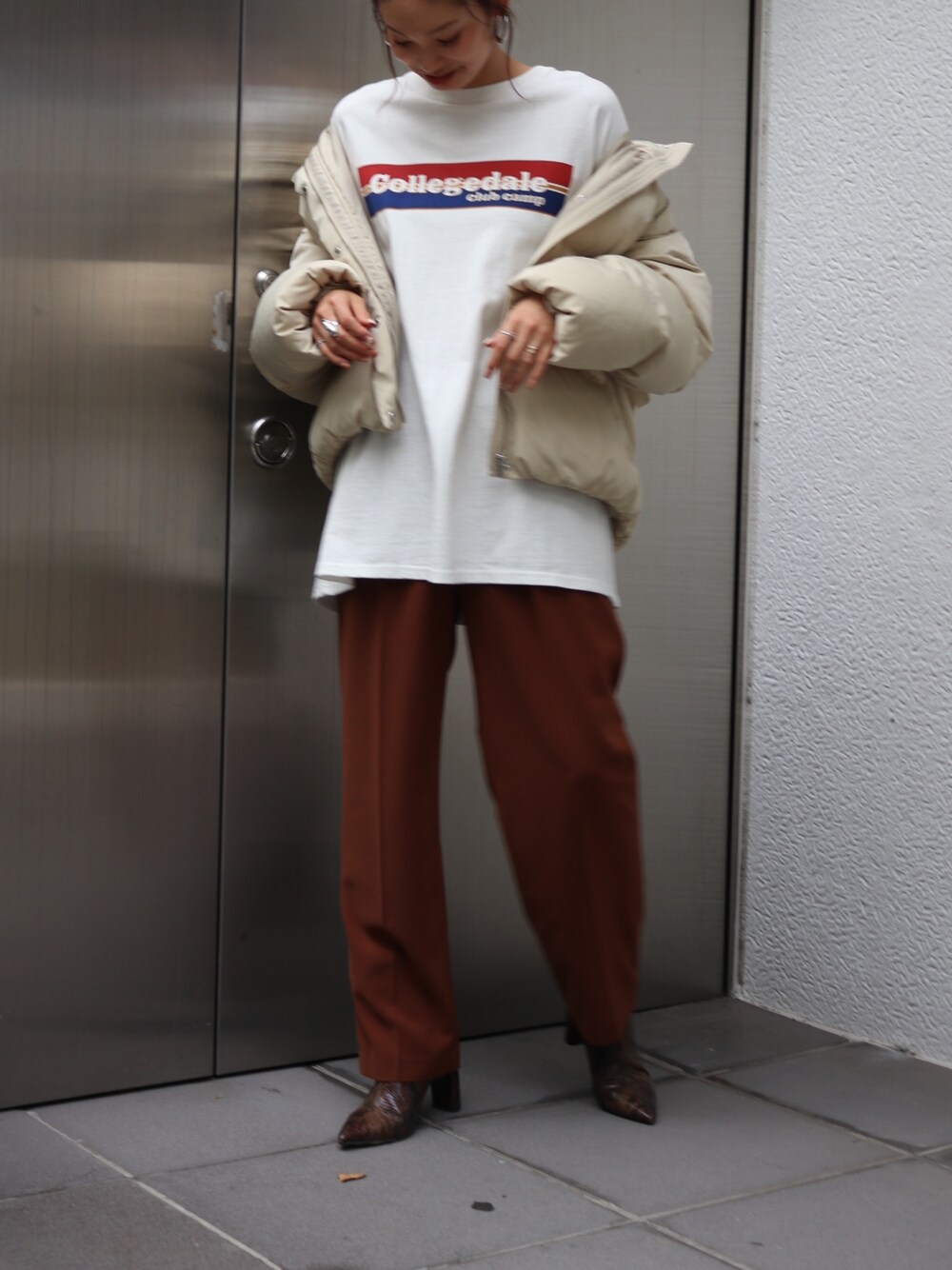 ブラウン系のその他パンツ、ホワイト系のダウンジャケット/コート、ホワイト系のTシャツ/カットソーを着用したレディースの秋コーディネートの1枚目の写真