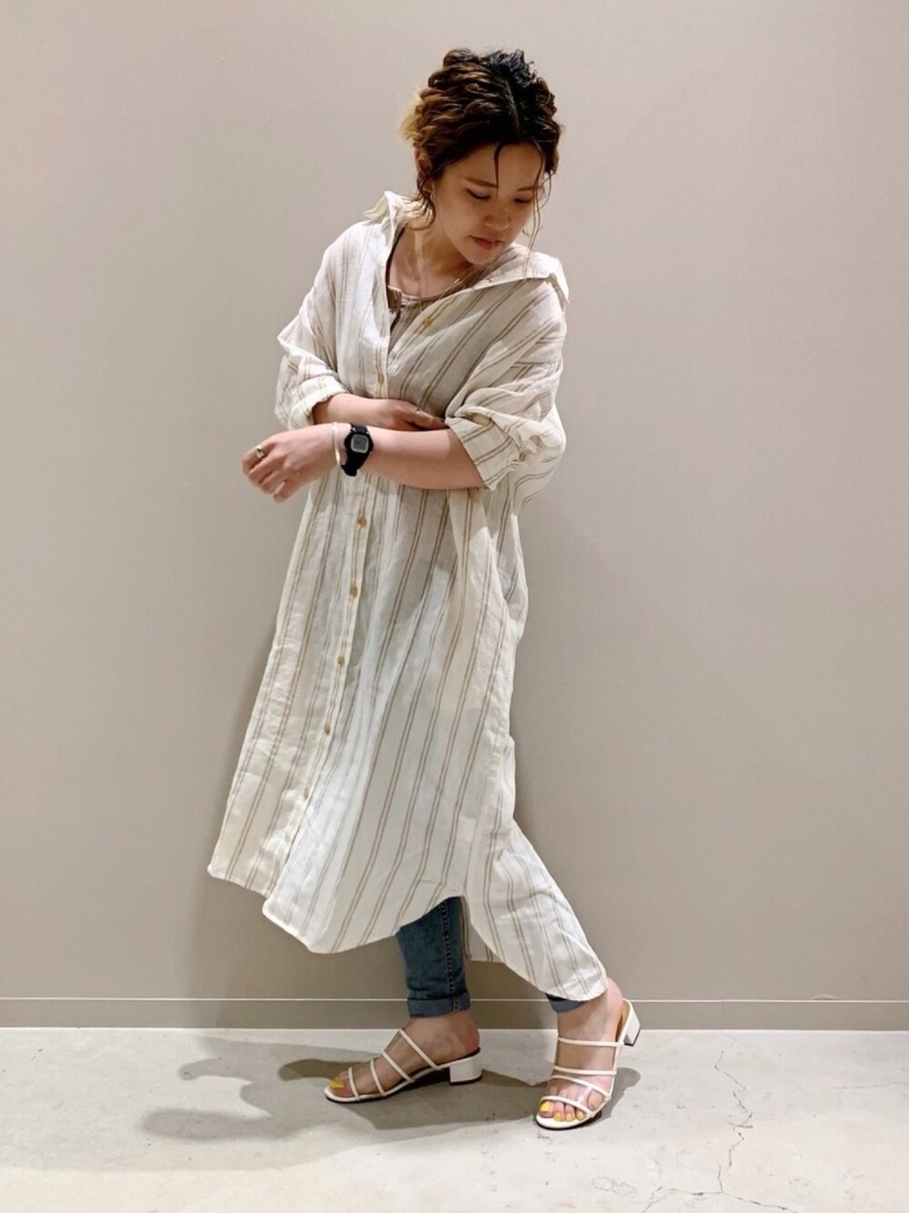 ベージュ系のシャツワンピースを着用したレディースの春コーディネートの1枚目の写真