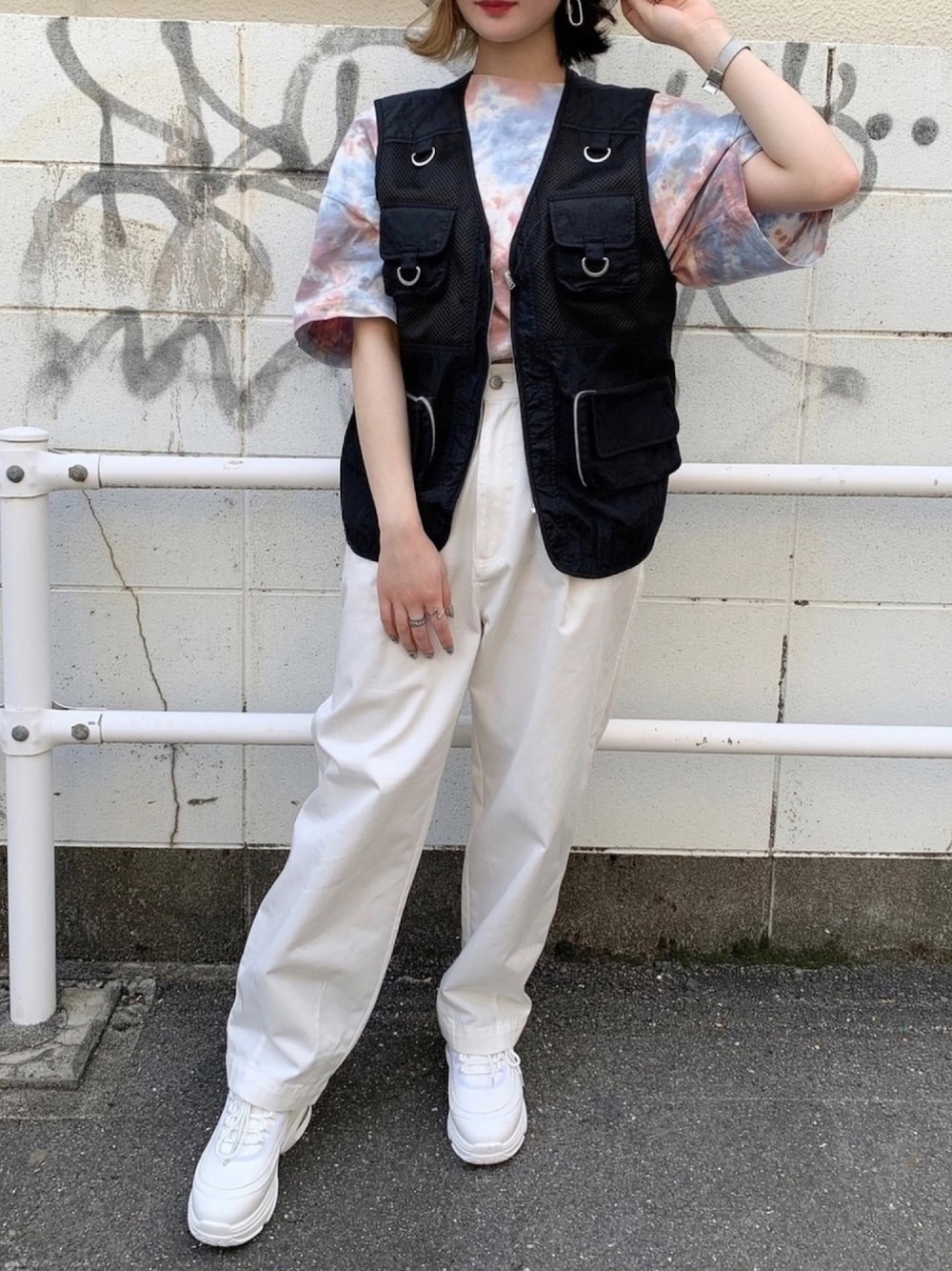 ピンク系のTシャツ/カットソー、ブラック系のベスト、ホワイト系のチノパンツを着用したレディースの春コーディネートの1枚目の写真