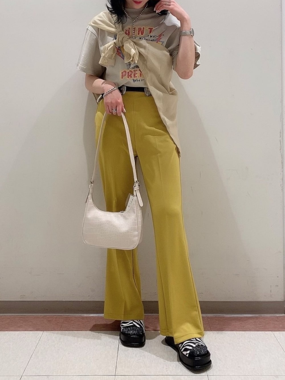 ベージュ系のTシャツ/カットソー、イエロー系のシャツ/ブラウス、イエロー系のパンツを着用したレディースの春コーディネートの1枚目の写真