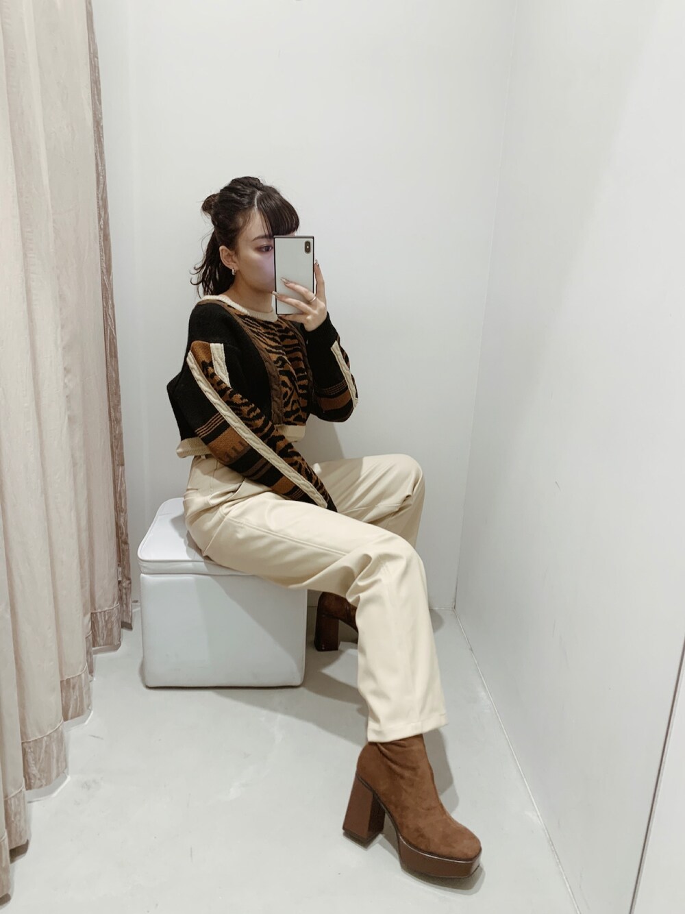 ブラウン系のニット/セーター、ホワイト系のその他パンツ、ブラウン系のブーツを着用したレディースの秋コーディネートの1枚目の写真