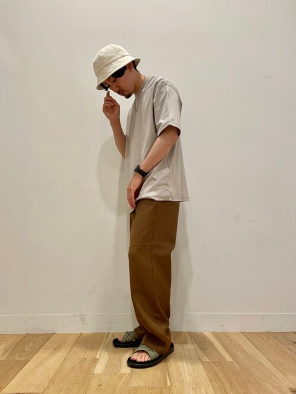 ベージュ系のTシャツ/カットソー、ブラウン系のその他パンツ、ホワイト系のハットを着用したメンズの夏コーディネートの1枚目の写真