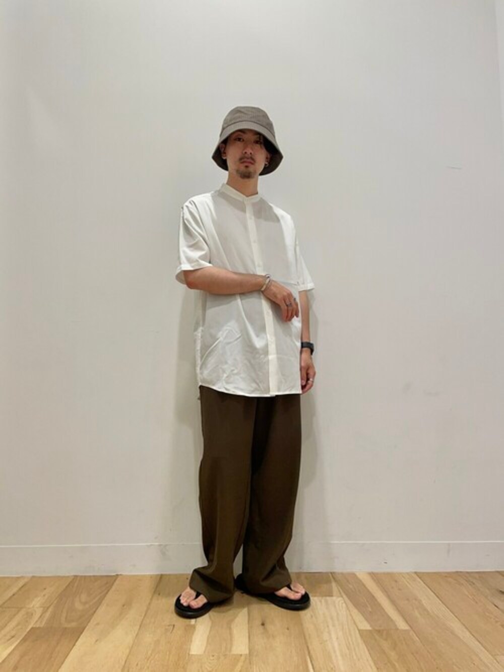 ホワイト系のシャツ/ブラウス、ブラウン系のスラックスを着用したメンズの夏コーディネートの1枚目の写真