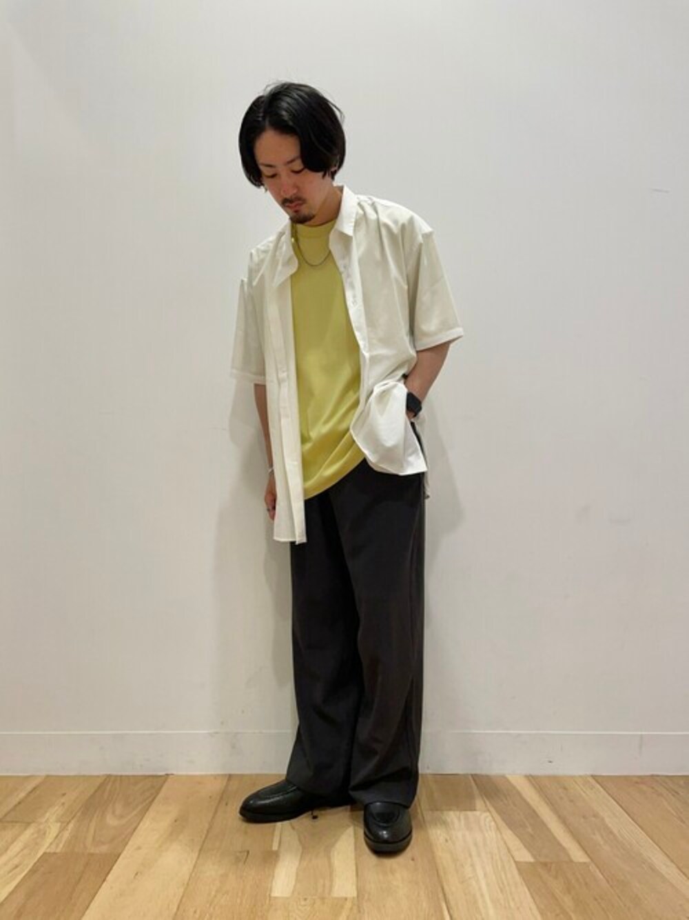ホワイト系のシャツ/ブラウス、イエロー系のTシャツ/カットソー、グレー系のスラックスを着用したメンズの秋コーディネートの1枚目の写真