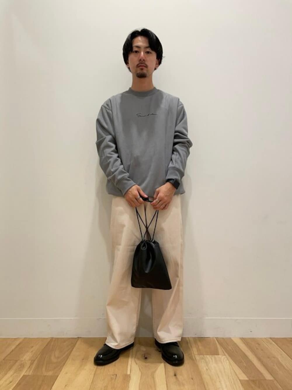 ブルー系のスウェット、ホワイト系のその他パンツ、ブラック系のショルダーバッグを着用したメンズの秋コーディネートの1枚目の写真