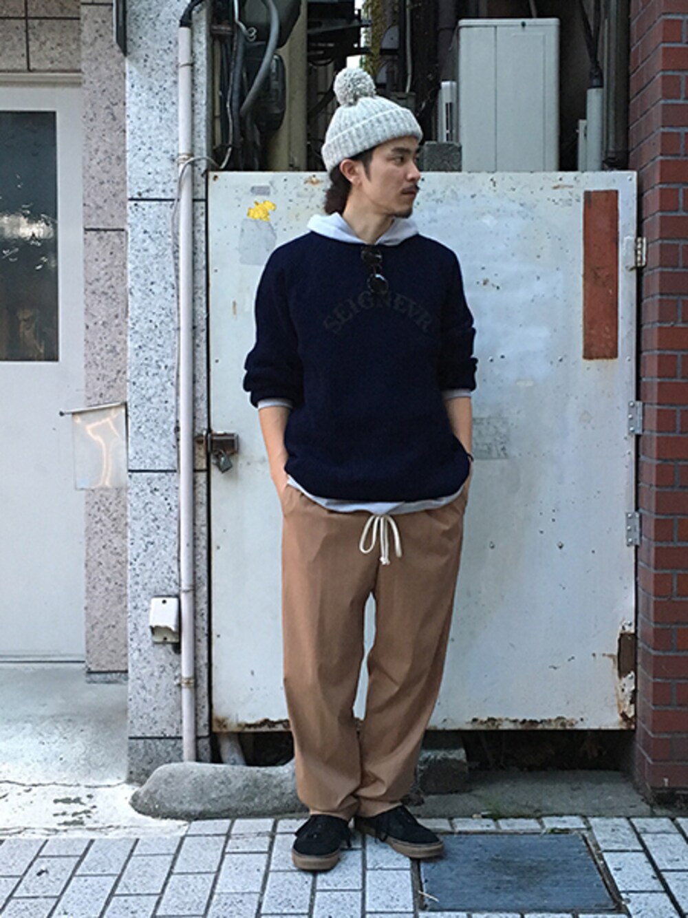 ブルー系のニット/セーター、グレー系のパーカー、ベージュ系のスラックスを着用したメンズの秋コーディネートの1枚目の写真