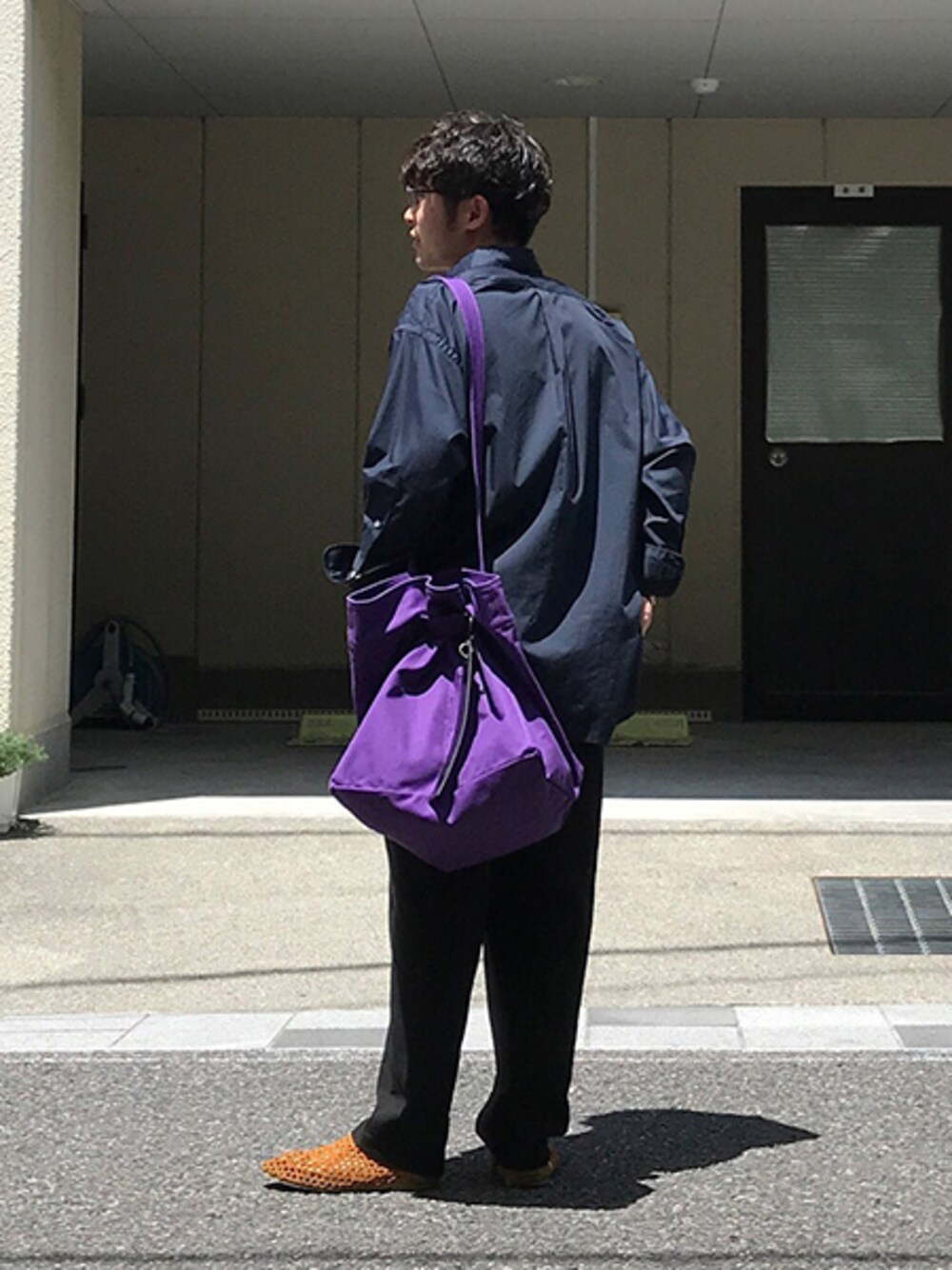 ブルー系のシャツ/ブラウス、ブラック系のその他パンツ、パープル系のトートバッグを着用したメンズの夏コーディネートの1枚目の写真