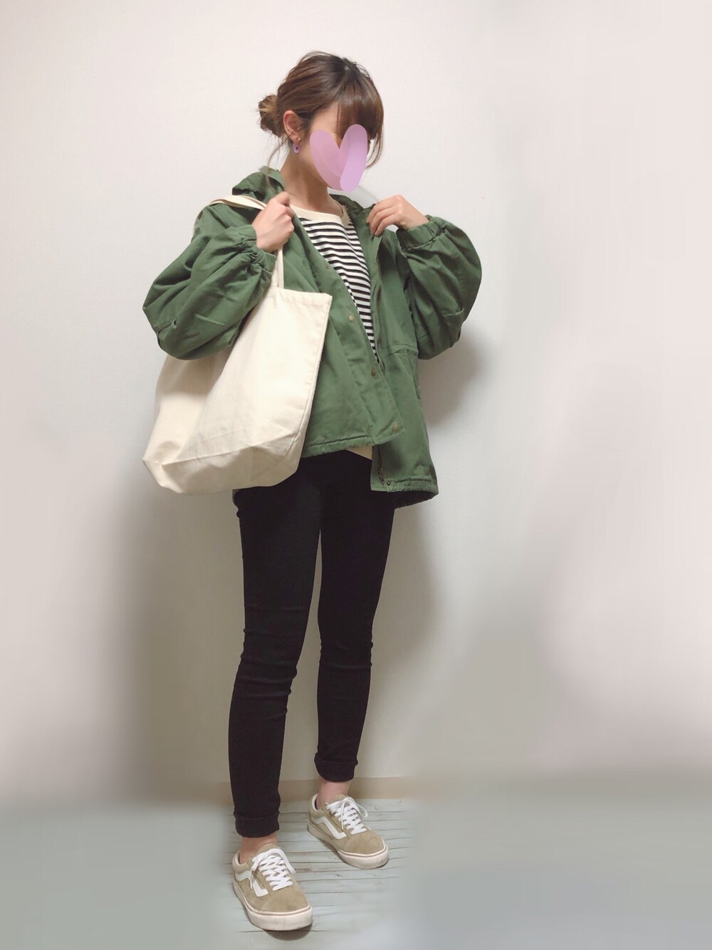 グリーン系のブルゾン、ブラック系のTシャツ/カットソー、ブラック系のデニムパンツを着用したレディースの春コーディネートの1枚目の写真