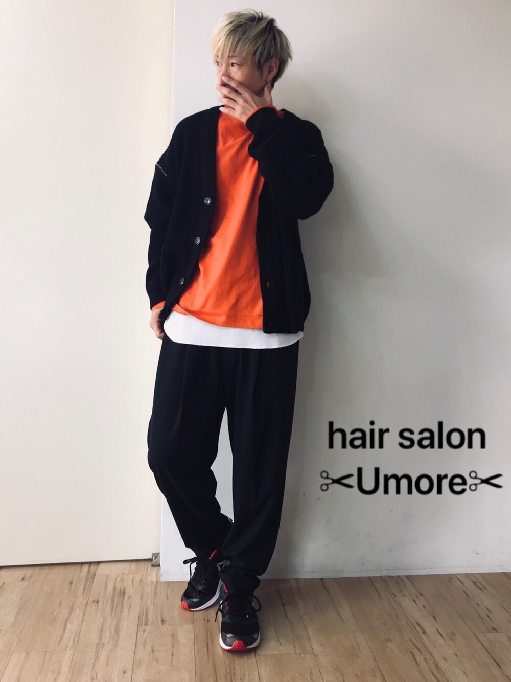 ブラック系のカーディガン/ボレロ、オレンジ系のTシャツ/カットソー、ブラック系のスラックスを着用したメンズの冬コーディネートの1枚目の写真