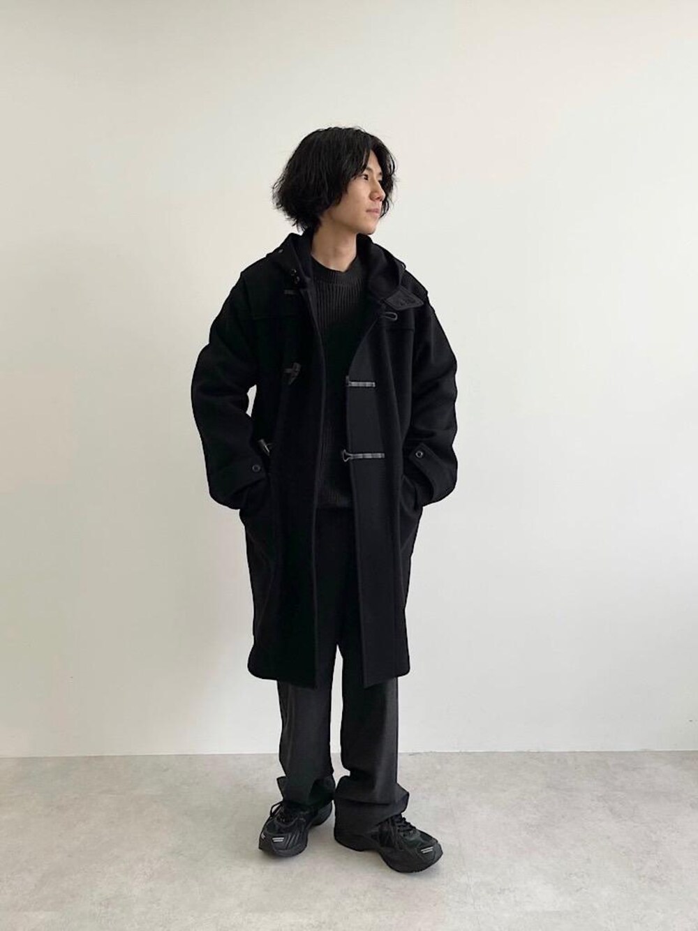 グレー系のその他パンツ、グレー系のニット/セーター、ブラック系のダッフルコートを着用したメンズの秋コーディネートの1枚目の写真