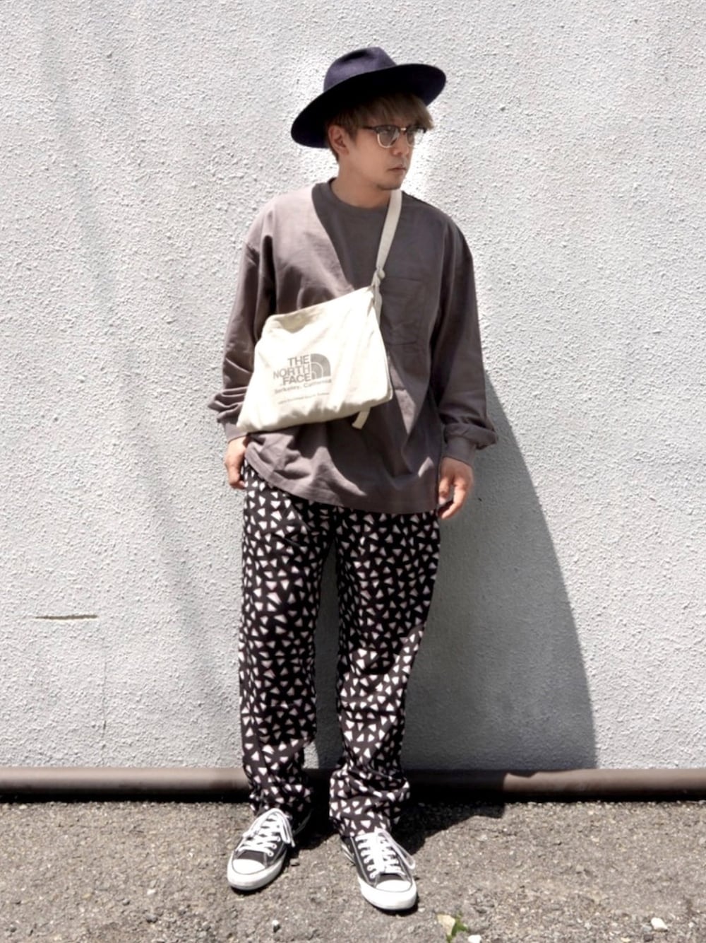グレー系のTシャツ/カットソー、ベージュ系のショルダーバッグ、ブラック系のその他パンツを着用したメンズの春コーディネートの1枚目の写真