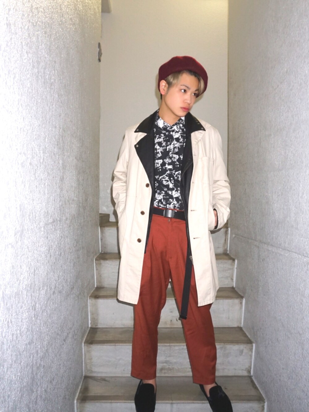 ブラック系のライダースジャケット、ベージュ系のステンカラーコート、ブラウン系のその他パンツを着用したメンズの春コーディネートの1枚目の写真