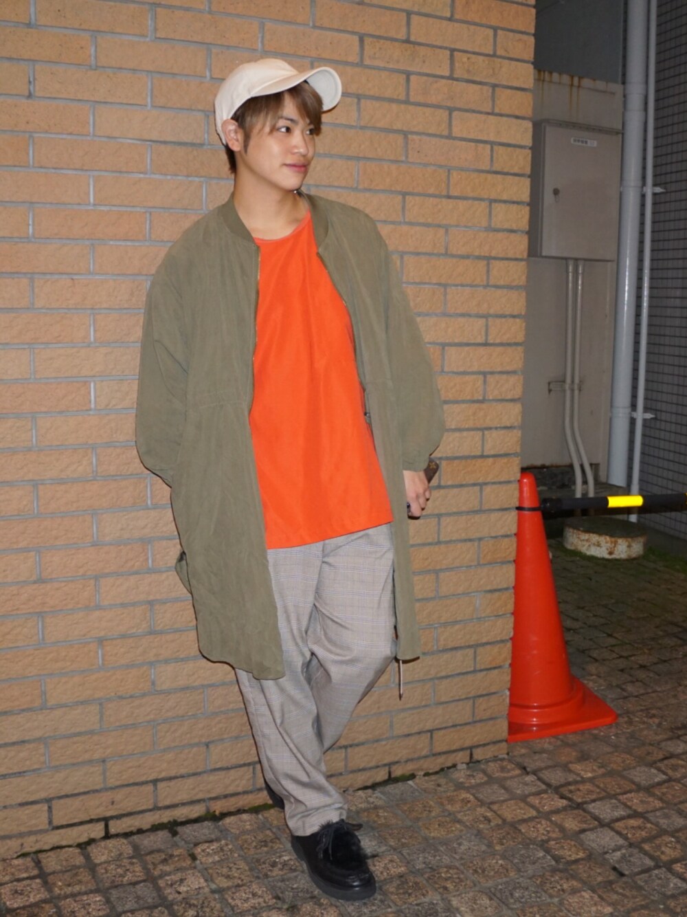 オレンジ系のTシャツ/カットソー、グリーン系のジャケット/アウター、ベージュ系のスラックスを着用したメンズの秋コーディネートの1枚目の写真