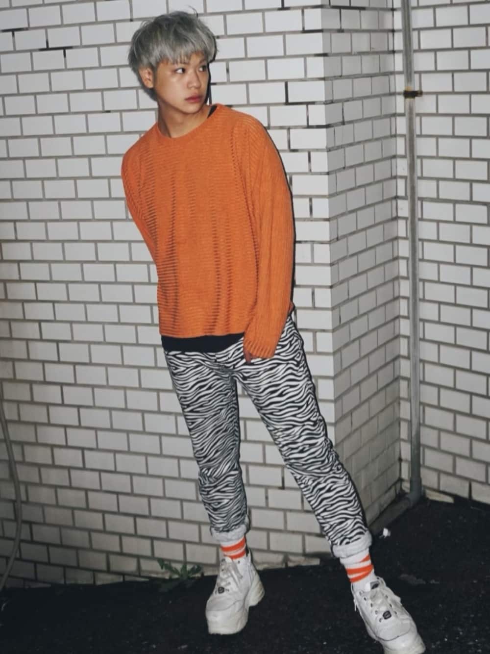 オレンジ系のTシャツ/カットソー、その他のその他パンツ、ホワイト系のスニーカーを着用したメンズの秋コーディネートの1枚目の写真