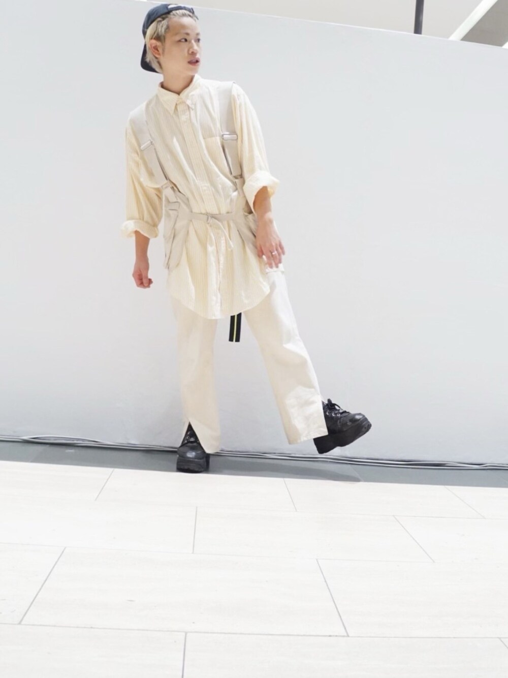 イエロー系のTシャツ/カットソー、ベージュ系のベスト、ホワイト系のデニムパンツを着用したメンズの秋コーディネートの1枚目の写真
