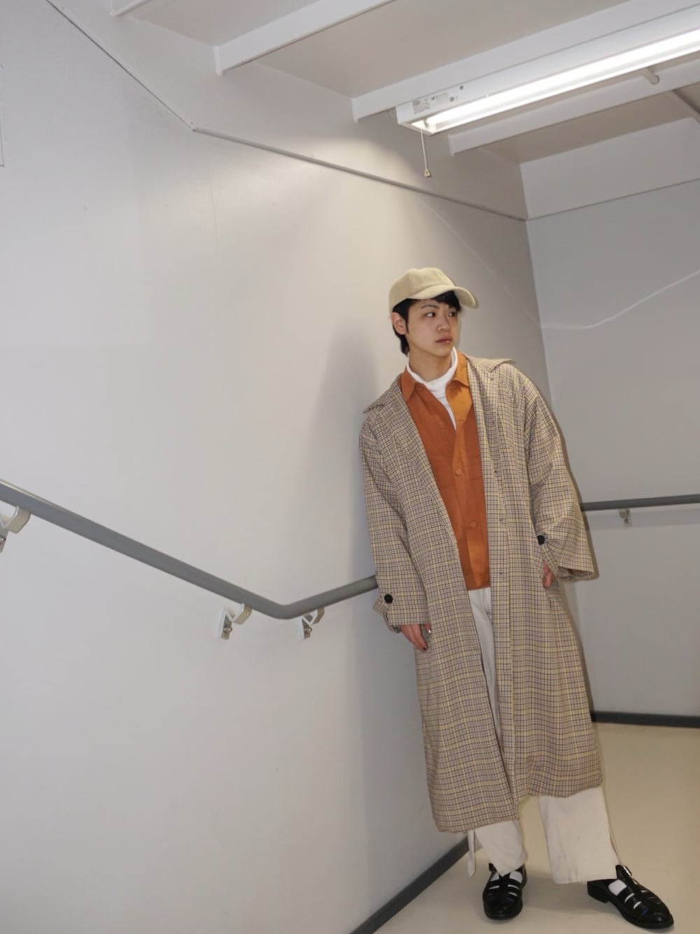 オレンジ系のジャケット/アウター、ホワイト系のTシャツ/カットソー、イエロー系のトレンチコートを着用したメンズの冬コーディネートの1枚目の写真