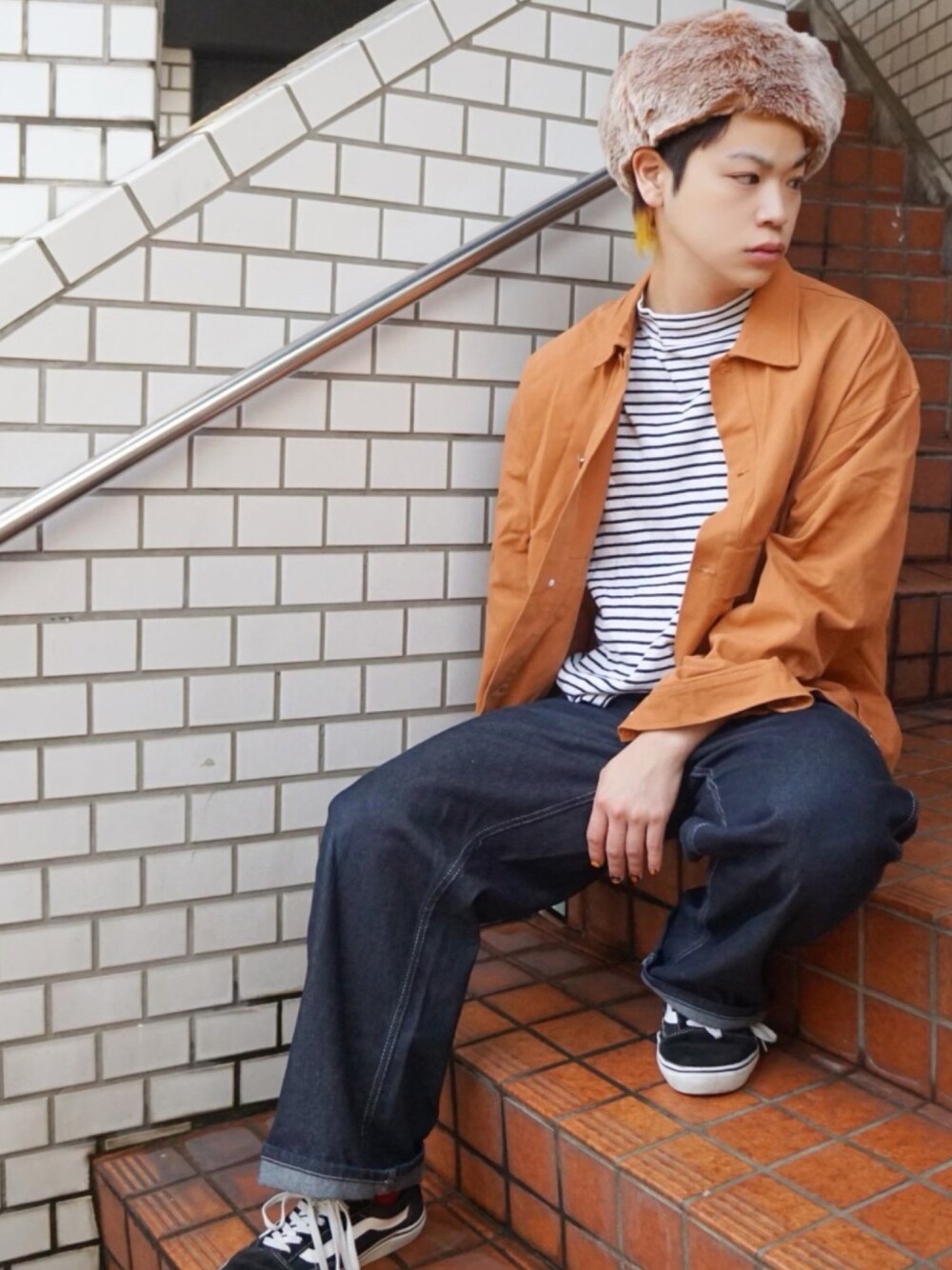 グレー系のTシャツ/カットソー、オレンジ系のジャケット/アウター、ブルー系のデニムパンツを着用したメンズの冬コーディネートの1枚目の写真