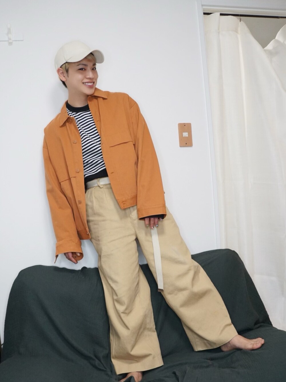 オレンジ系のジャケット/アウター、ブラック系のTシャツ/カットソー、ベージュ系のその他パンツを着用したメンズの春コーディネートの1枚目の写真