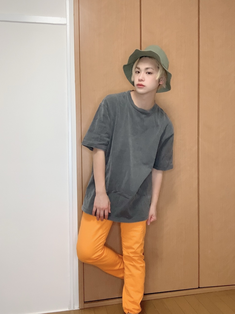 ブラック系のTシャツ/カットソー、オレンジ系のパンツ、グリーン系のハットを着用したメンズの夏コーディネートの1枚目の写真