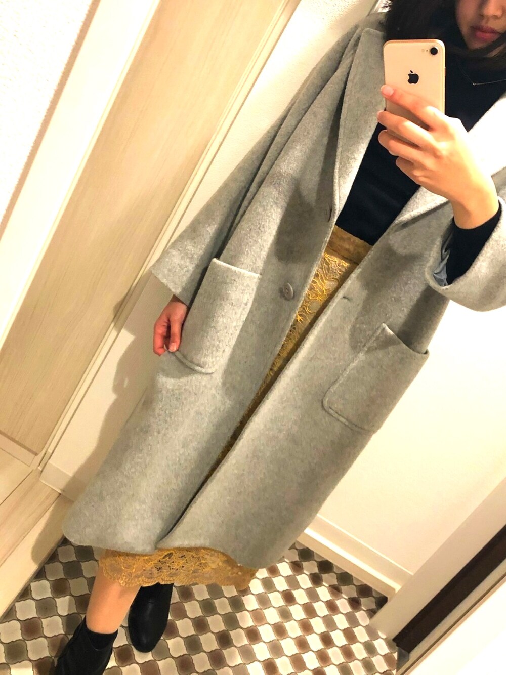 ブルー系のニット/セーター、ベージュ系のスカート、ブラック系のブーツを着用したレディースの冬コーディネートの1枚目の写真