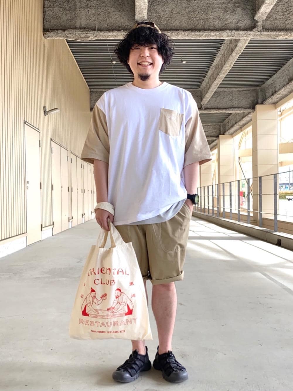 グレー系のタンクトップ、レッド系のトートバッグ、ベージュ系のその他パンツを着用したメンズの春コーディネートの1枚目の写真