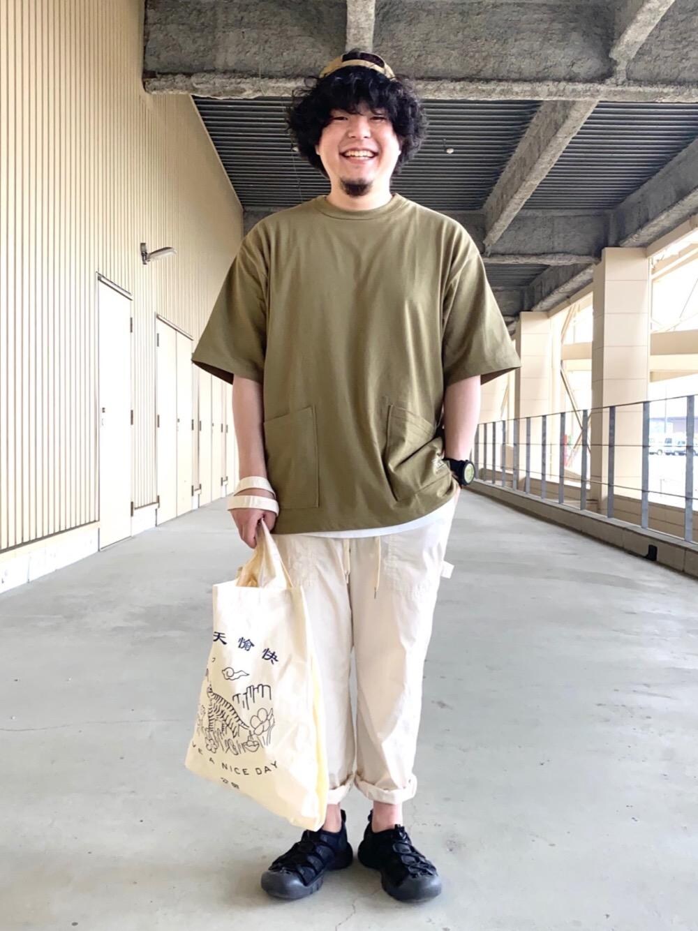 ホワイト系のその他パンツ、ブルー系のトートバッグ、グリーン系のTシャツ/カットソーを着用したメンズの春コーディネートの1枚目の写真