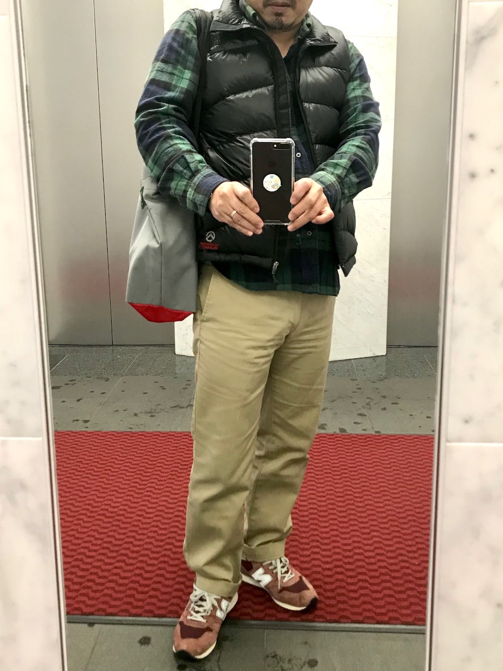 「ビジネスカジュアル、チノパンコーデ、雨の日、ニューバランス996、ネルシャツ、ダウンベスト、ヒゲ」｜「Dickiesのアイテム（チノパンツ、ベージュ系）」を使った、Kanさん（メンズ・168cm）の秋コーディネートの1枚目の写真