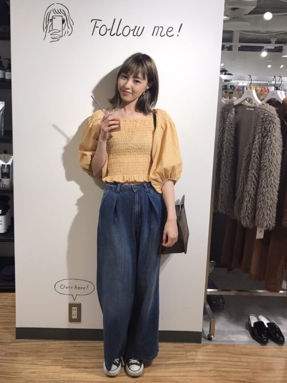 イエロー系のTシャツ/カットソー、ブラウン系のショルダーバッグ、シルバー系のイヤリングを着用したレディースの秋コーディネートの1枚目の写真