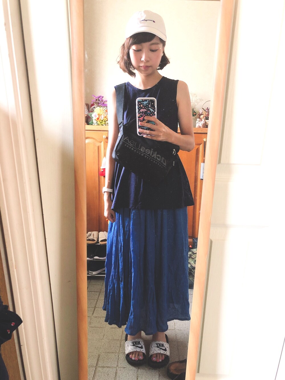 ブルー系のタンクトップ、ブラック系のショルダーバッグ、ブラック系のサンダルを着用したレディースの夏コーディネートの1枚目の写真