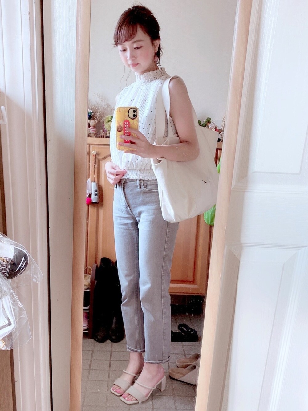 ベージュ系のシャツ/ブラウス、ホワイト系のトートバッグ、グレー系のデニムパンツを着用したレディースの秋コーディネートの1枚目の写真