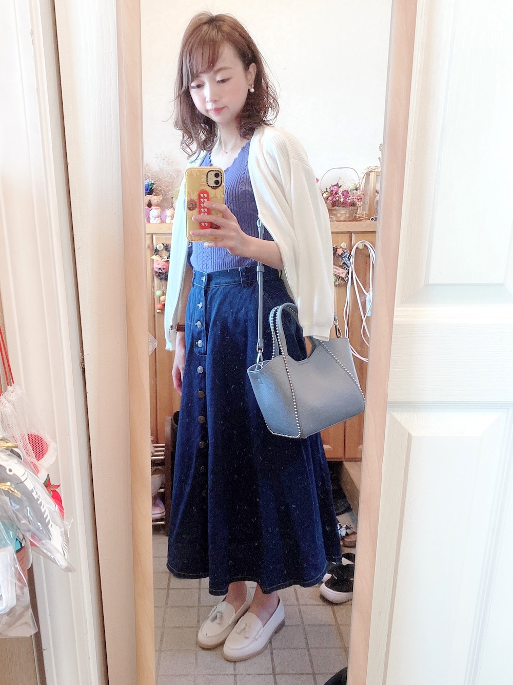 ホワイト系のカーディガン/ボレロ、ブルー系のニット/セーター、ブルー系のバッグを着用したレディースの秋コーディネートの1枚目の写真