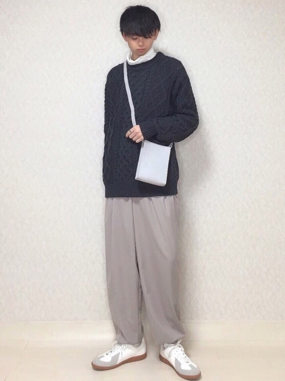 グレー系のニット/セーター、ホワイト系のTシャツ/カットソー、ベージュ系のその他パンツを着用したメンズの冬コーディネートの1枚目の写真