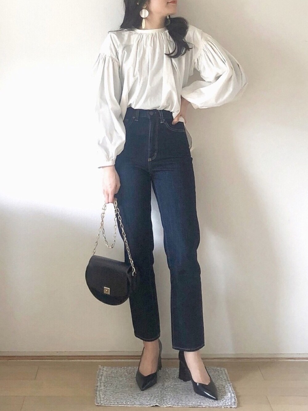 ホワイト系のシャツ/ブラウス、ブルー系のデニムパンツ、ブラック系のパンプスを着用したレディースの冬コーディネートの1枚目の写真