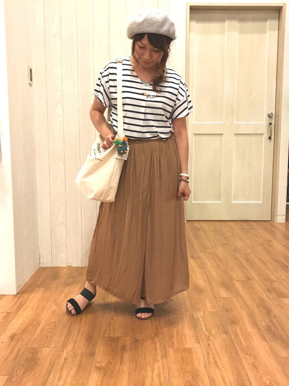 ブルー系のTシャツ/カットソー、ベージュ系のパンツ、ホワイト系のショルダーバッグを着用したレディースの夏コーディネートの1枚目の写真