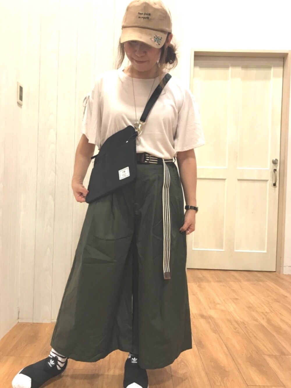 ベージュ系のTシャツ/カットソー、ブラック系のバッグ、グリーン系のパンツを着用したレディースの夏コーディネートの1枚目の写真