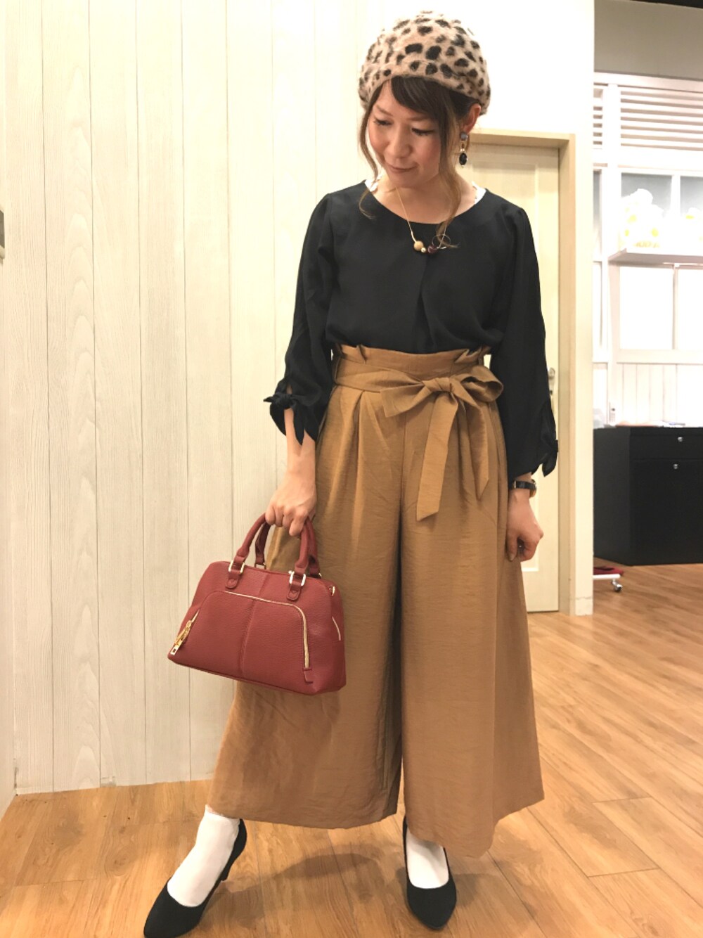 ブラック系のシャツ/ブラウス、ブラウン系のその他パンツ、レッド系のボストンバッグを着用したレディースの秋コーディネートの1枚目の写真