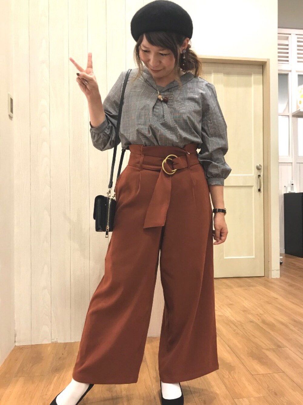 ブラック系のシャツ/ブラウス、オレンジ系のパンツ、ブラック系のパンプスを着用したレディースの秋コーディネートの1枚目の写真