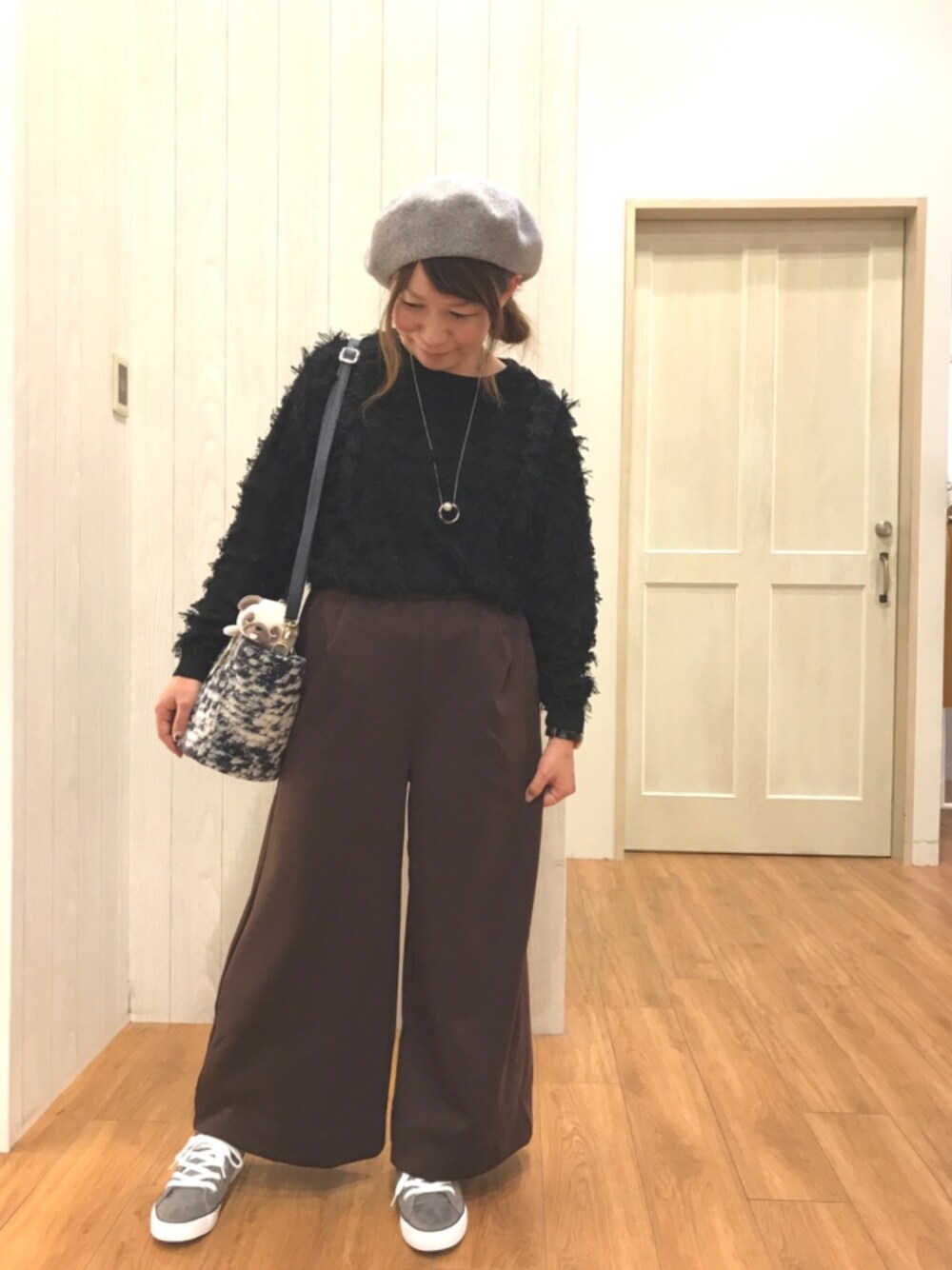 ブラック系のニット/セーター、ブラウン系のその他パンツ、ブルー系のバッグを着用したレディースの秋コーディネートの1枚目の写真