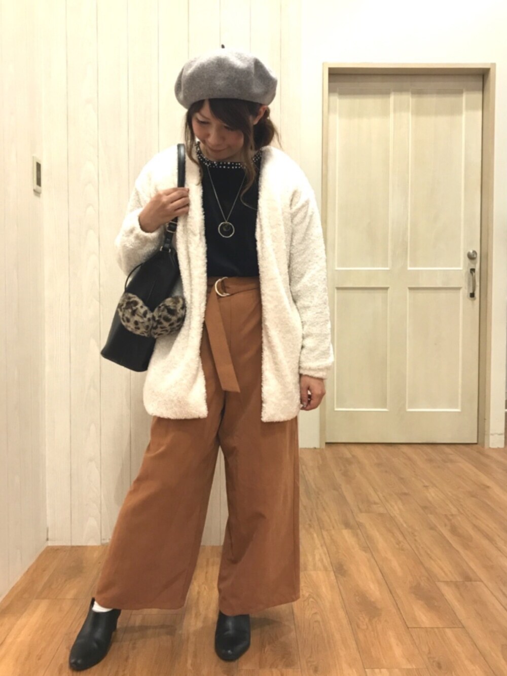 ブラック系のニット/セーター、ホワイト系のノーカラージャケット、ブラウン系のその他パンツを着用したレディースの秋コーディネートの1枚目の写真