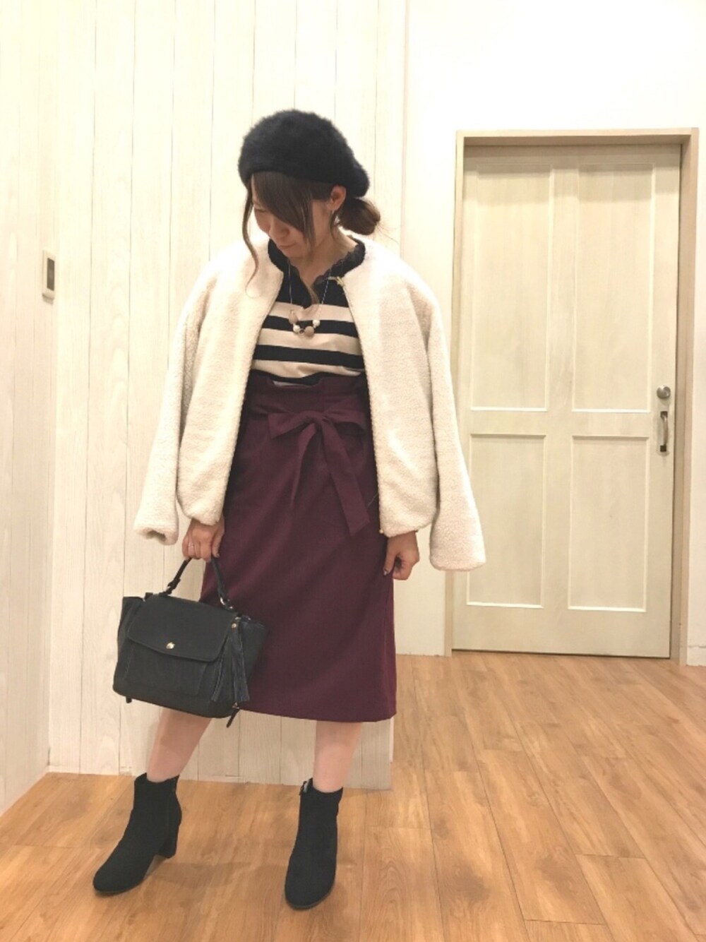 ホワイト系のブルゾン、ブラック系のニット/セーター、レッド系のスカートを着用したレディースの秋コーディネートの1枚目の写真