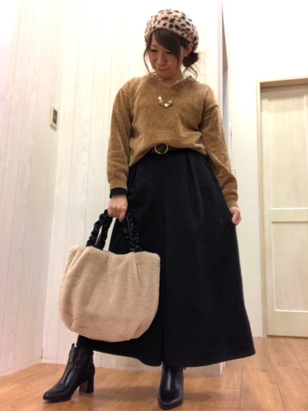 ブラウン系のニット/セーター、ブラック系のその他パンツ、ベージュ系のトートバッグを着用したレディースの冬コーディネートの1枚目の写真
