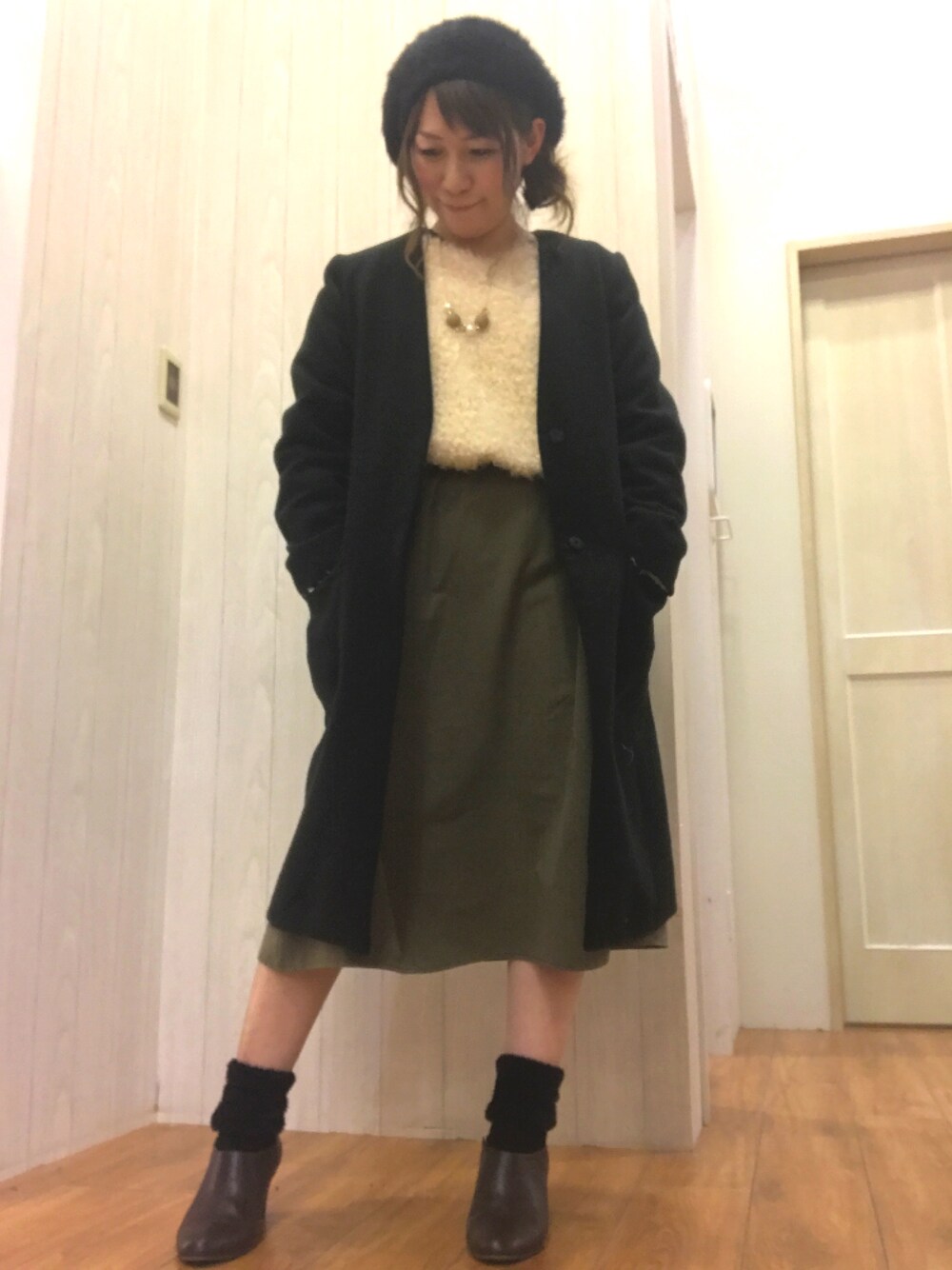 ホワイト系のワンピース、ブラック系のその他アウター、ブラウン系のブーツを着用したレディースの冬コーディネートの1枚目の写真