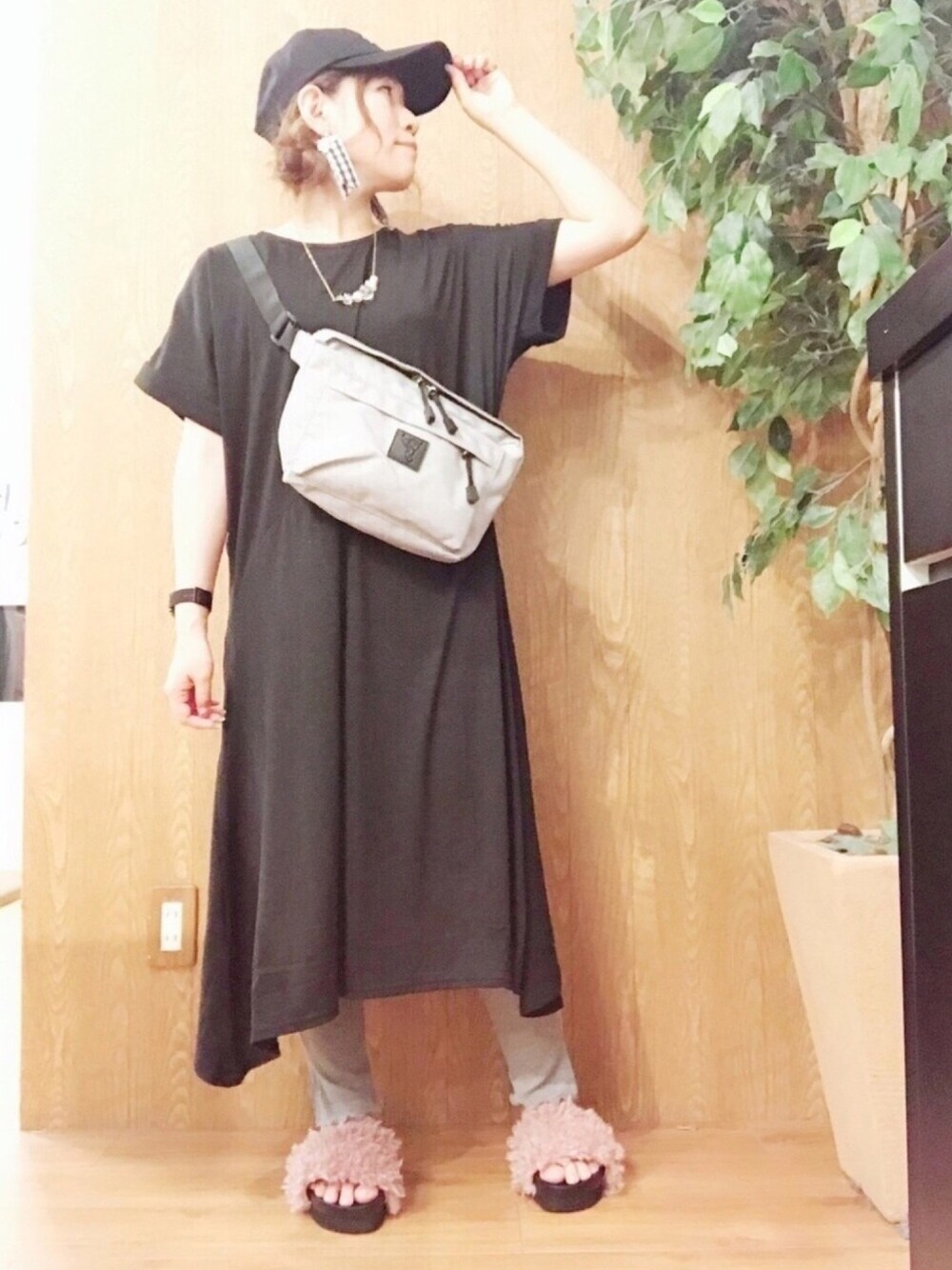 グレー系のバッグ、グレー系のパンツ、ピンク系のサンダルを着用したレディースの夏コーディネートの1枚目の写真