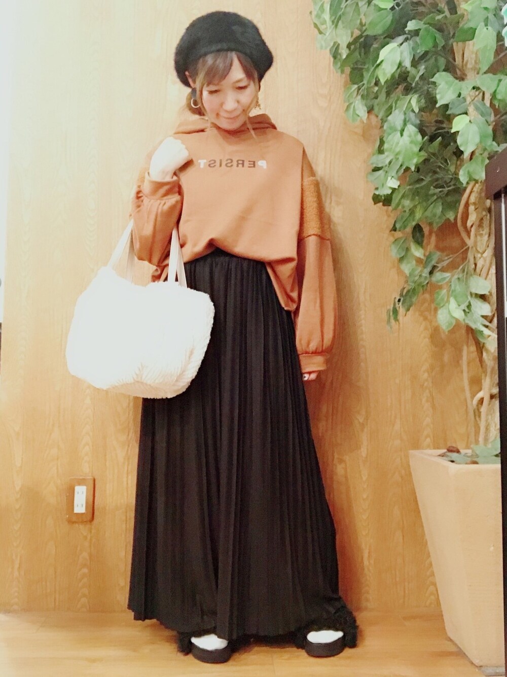 ブラウン系のトップス、ブラック系のパンツ、ベージュ系のショルダーバッグを着用したレディースの秋コーディネートの1枚目の写真